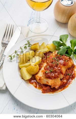 Plate of Cod or Pollack Cooked in Tomato and Thyme Sauce Garnished with Boiled New Potatoes