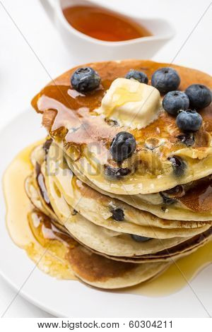 Big Pile of American Blueberry Pancakes with Berries and Maple Syrup