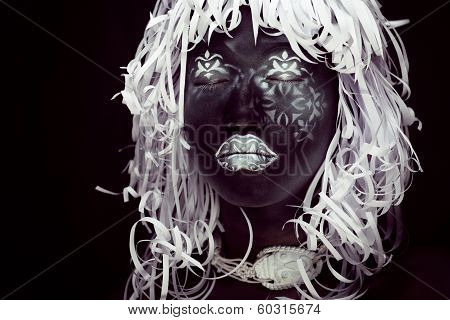 creative make up like Ethiopian mask, white pattern on black face close up