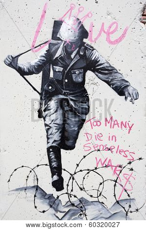 BERLIN GERMANY - 18 NOVEMBER 2013:Graffiti on a wall in Berlin depicting a Nazi soldier, with the slogan 'too many die in senseless wars', Hannah-Arendt Strasse, Berlin, Germany
