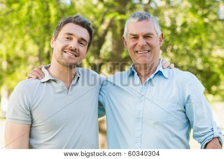 Portrait of a smiling father with adult son at the park