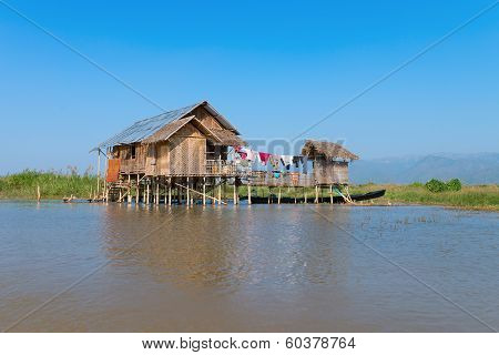 Traditional Stilts House In Water Under Blue Sky