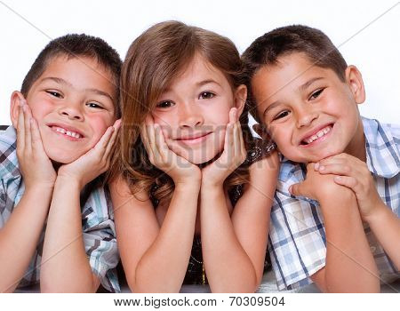 Portrait of three children, two boys and a girl aged between 5 and 8 isolated against white background