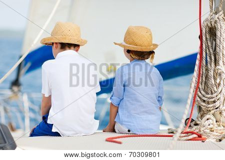 Back view of kids enjoying sailing on a luxury catamaran or yacht