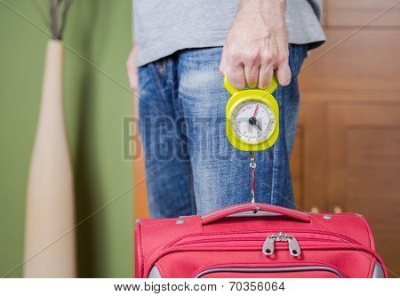 Man checking luggage weight with steelyard balance