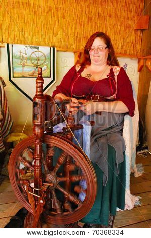 MUSKOGEE, OK - MAY 24:  A woman works at a vintage spinning wheel making yarn at the Oklahoma 19th annual Renaissance Festival on May 24, 2014 at the Castle of Muskogee in Muskogee, OK 