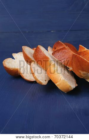 baked product : cutted golden challah on blue wooden table