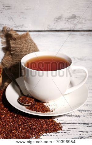 Cup of tasty rooibos tea, on old white wooden table