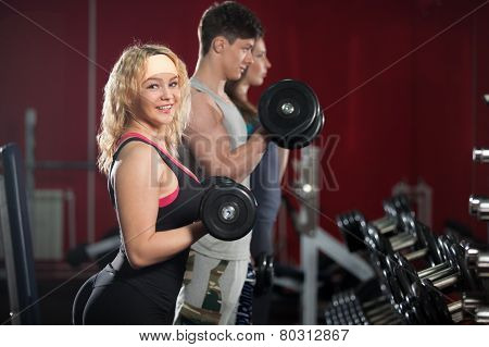 Group Of People Training With Freeweights In Fitness Center