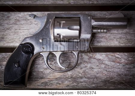 MARYLAND, USA - CIRCA DEC 2014: A staged close-up of an H & R .32 caliber pistol on a gray wooden table, shallow depth of field.