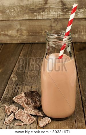 Chocolate milk in bottle on wood