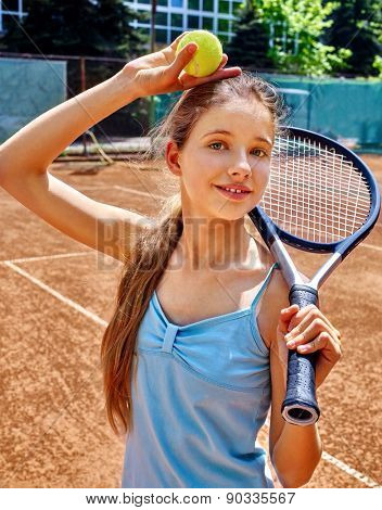 Teenager girl athlete with racket and ball on  brown tennis court.