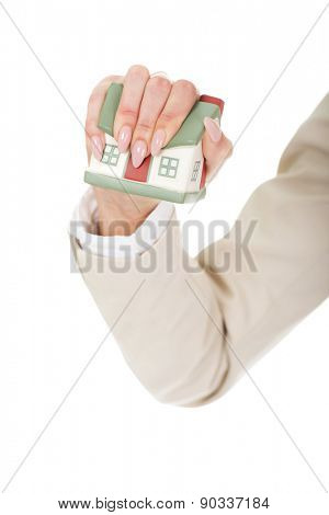 Aggresive businesswoman crushing small house.