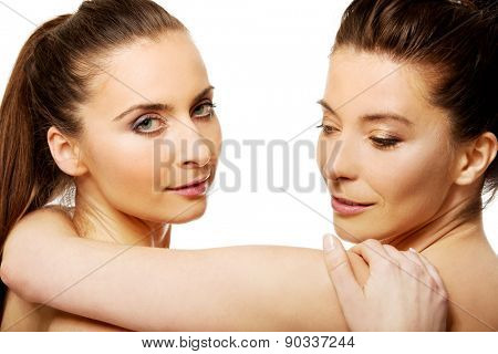 Two attractive sisters with make up embracing.