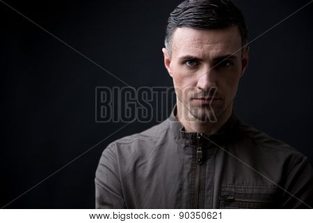 Portrait of a handsome man looking at camera over black background