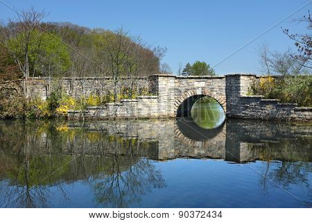SETAUKET, NY - MAY 4, 2015: Bridge at Frank Melville Memorial Park. Constructed in 1937 and privately owned, the parks twenty-four acres include a circular walkway around the upper pond.