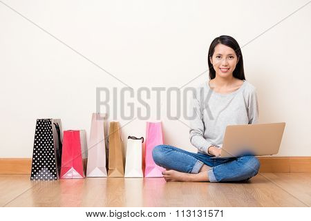 Woman using lapop computer for online shopping bag