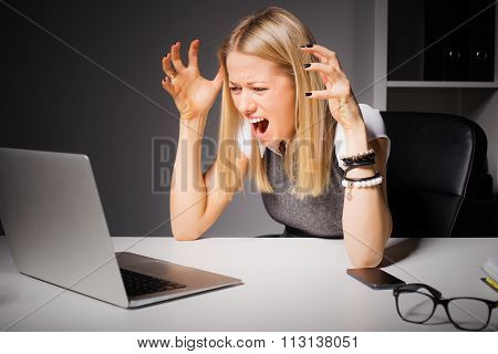 Woman looking at computer and going crazy