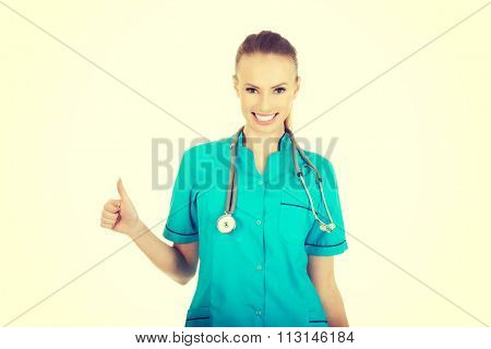 Beautiful smiling woman doctor with thumbs up.