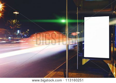 Public information board with blurred cars lights on background