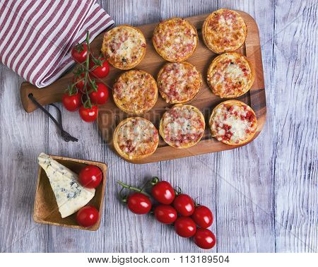Mini Pizzas On A Wooden Table