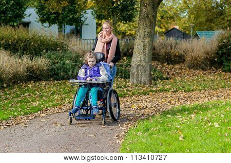Disability a disabled child in a wheelchair relaxing outside