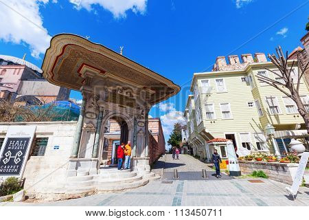 ISTANBUL, TURKEY - APRIL 10, 2015: Almshouse door of Hagia Sophia with unidentified people. Hagia Sophia Almshouse was a charity built by Sultan Mahmud I in 1743 for distributing food to poor people