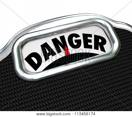 Danger word on a scale display to illustrate a warning of disease, sickness or obesity risk