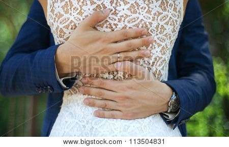 man hugs his woman on hill with beautiful view behind