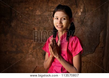 Young Myanmar girl in a traditional welcoming gesture.