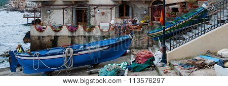 Two blue and green boats sitting on land in small italian town Scilla