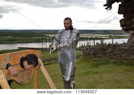 Statement of medieval execution. Knightly armor and weapon. Semi - antique photo.