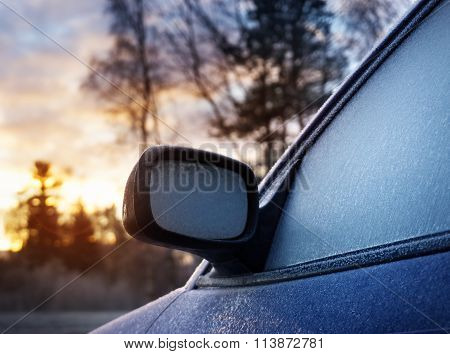 Car window and side mirror covered with ice in the morning