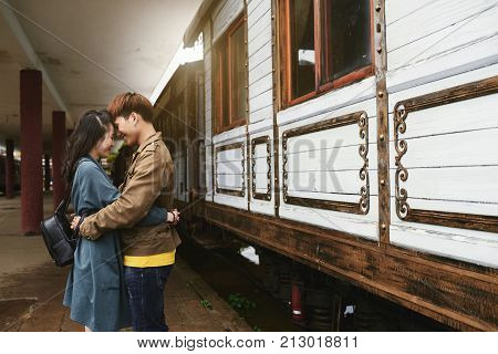Vietnamese young couple hugging at train station