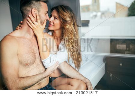 Attractive young couple sharing intimate moments in bedroom