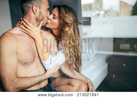 Attractive young couple sharing intimate moments in bedroom