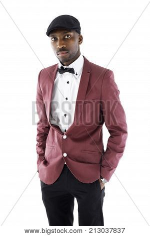 African male with his hands in his pockets is dressed in a vintage suit standing with a blank expression