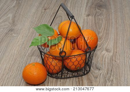 Clementines in a basket on a wooden table