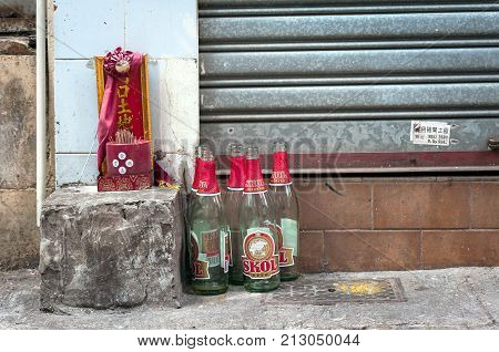 HONG KONG - SEPT 20, 2013 - Small shrine and beer bottles on a Hong Kong street.