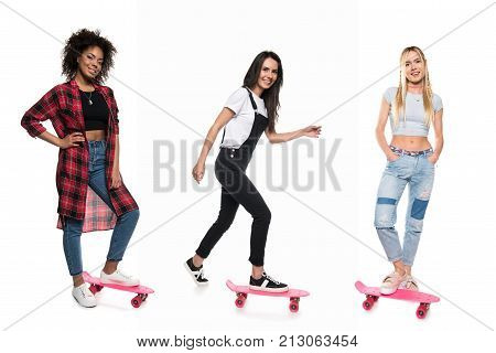 young multicultural women on pennyboards isolated on white