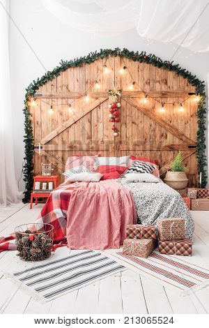 Xmas in morning bedroom. Double bed In christmas Interior on wood wall background.