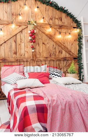 Xmas in morning bedroom. Double bed In christmas Interior on wood wall background.