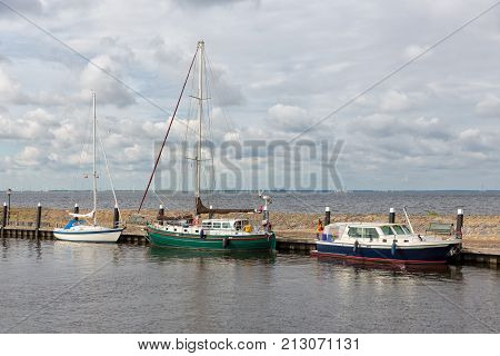 Harbor of historic Dutch village Urk with modern sailing yachts moored to a pier