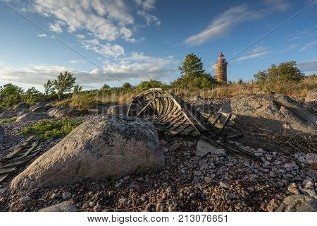 Lighthouse and house in the Baltic Sea. Shore evening light sunset clouds and architecture concept. Mohni small island in Estonia Europe.