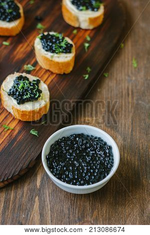 Fresh black caviar in a white ceramic bowl