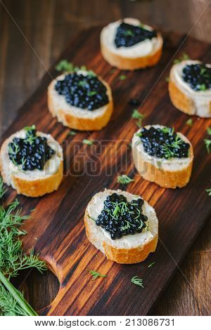 Appetizer for christmas table - black caviar on the pieces of bread
