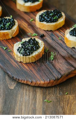 Black caviar over the wooden kitchen table.