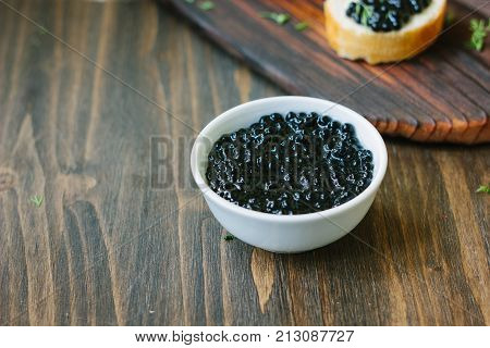 Fresh black caviar in a white ceramic bowl