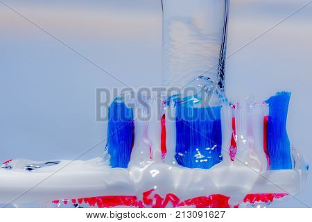 View of colorful tooth brush under water fall.