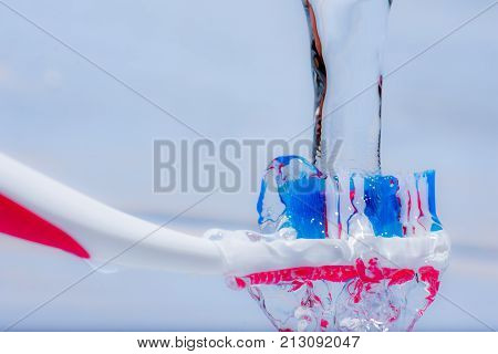 View of colorful tooth brush under water fall.